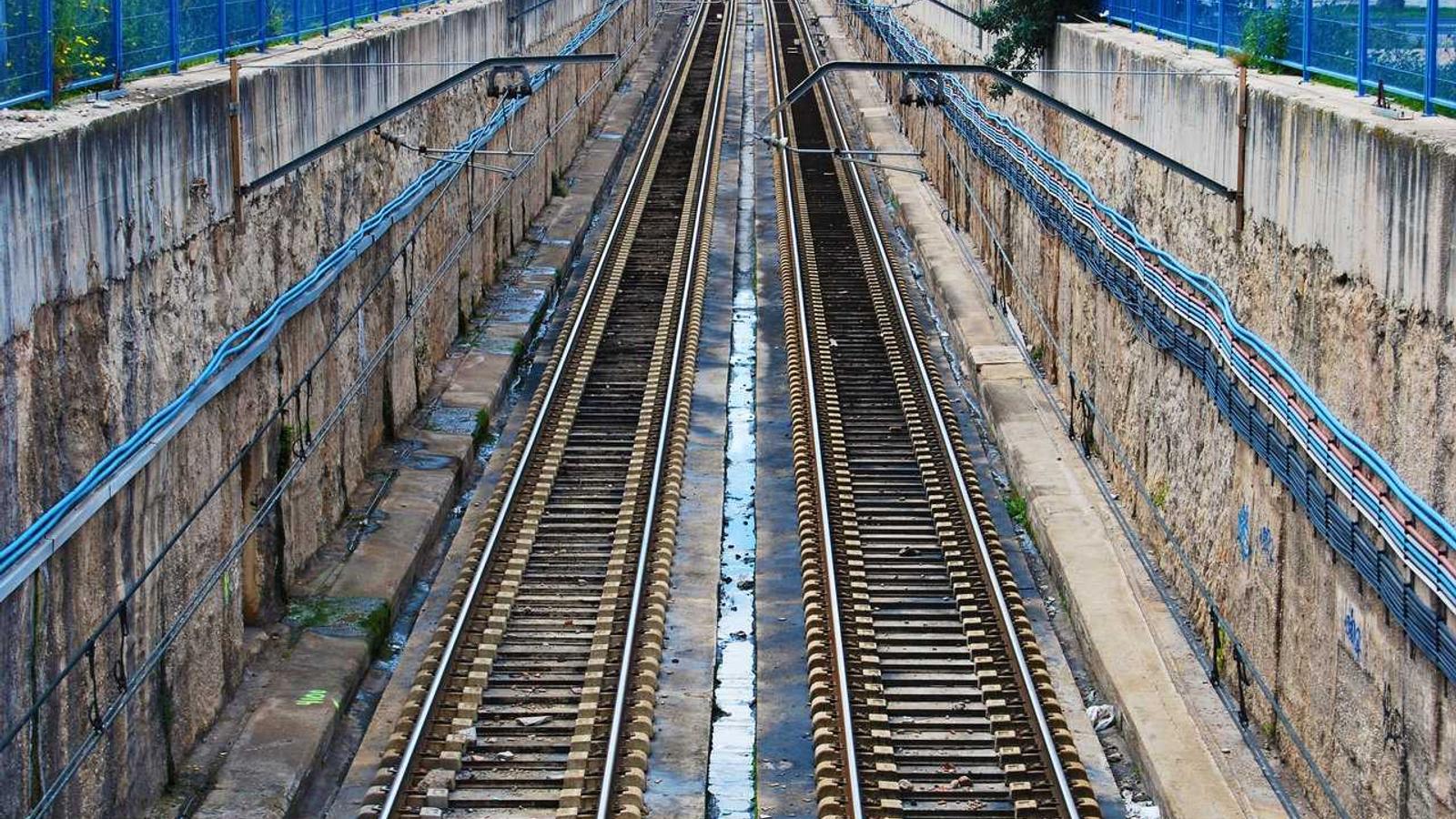 A writer working at a laptop with sales dashboard charts open showing book royalty earnings, with handwritten income calculations on a notepad and a small espresso cup beside the keyboard.