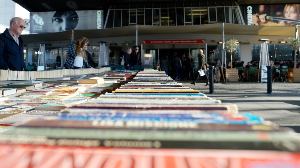 &Eacute;tal de livres d'occasion en plein air, volumes serr&eacute;s et dos us&eacute;s align&eacute;s