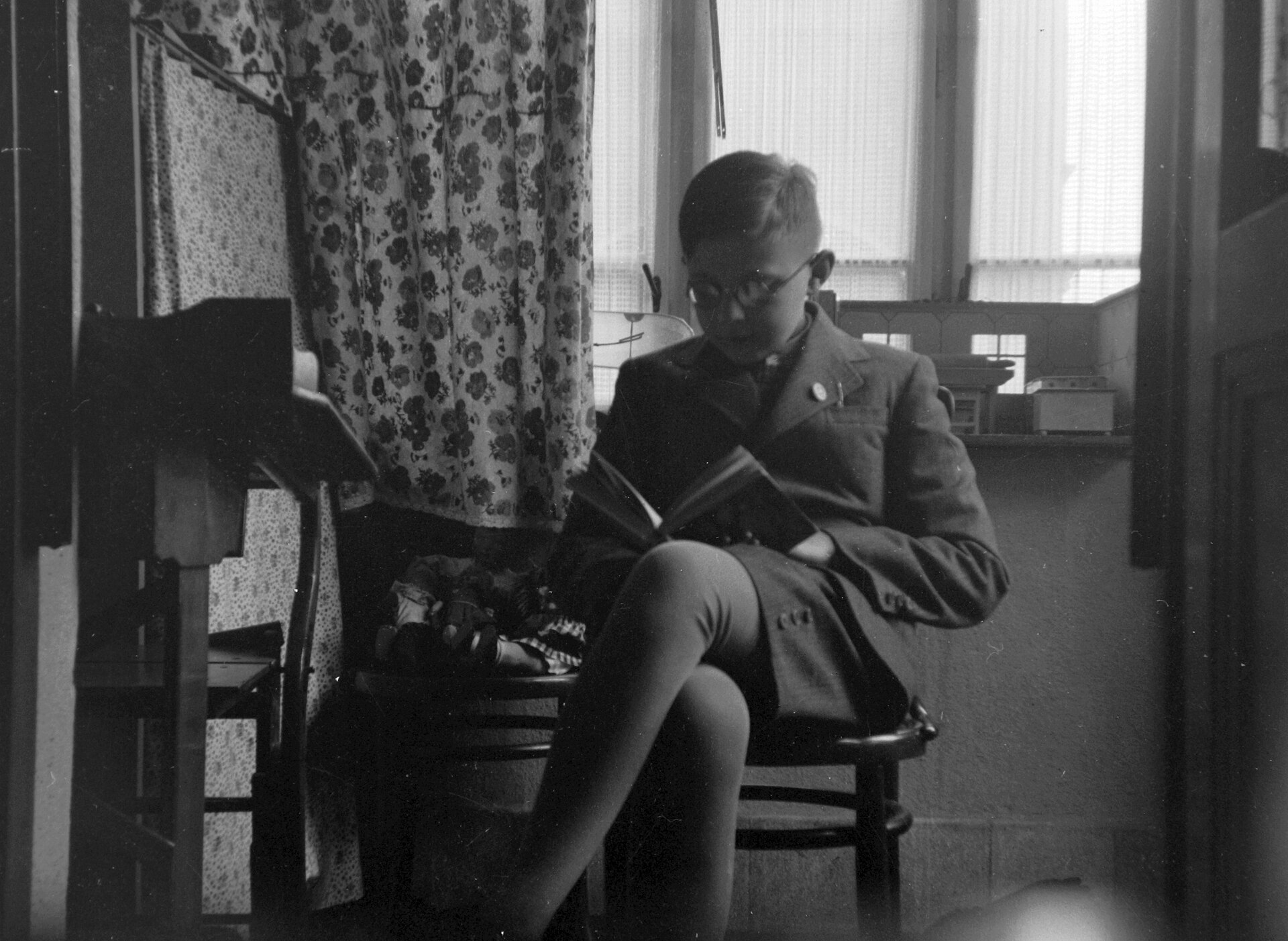 Paire de lunettes posée sur un livre ouvert, à côté d'un carnet fermé sur une table