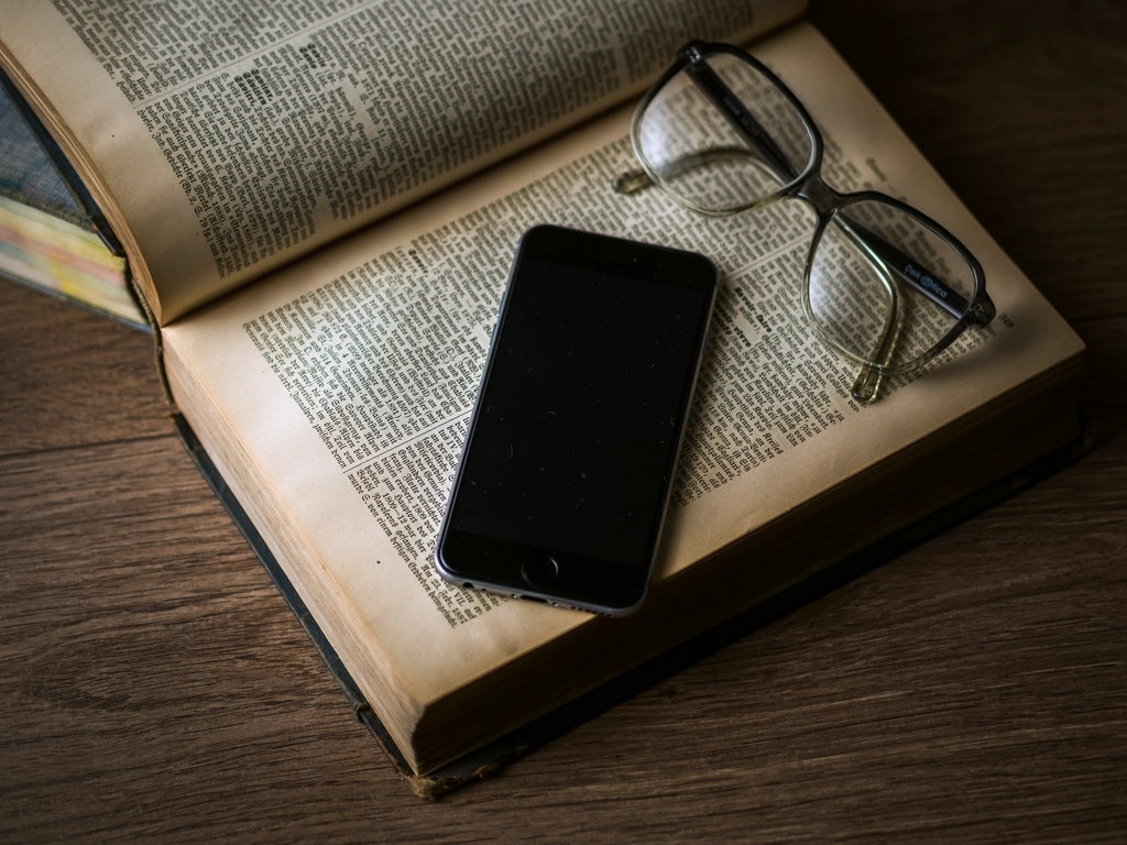 T&eacute;l&eacute;phone tenu &agrave; la main affichant un texte de lecture, pouce pr&egrave;s du bord de l'&eacute;cran