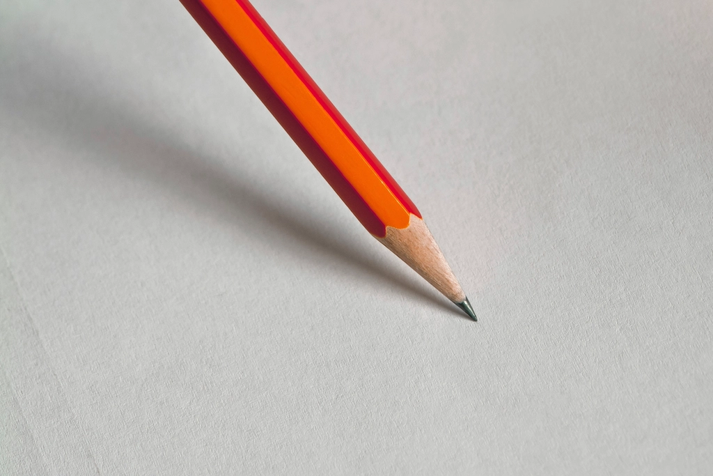 Feuilles de papier vierges et stylos pos&eacute;s en d&eacute;sordre sur une table de r&eacute;union