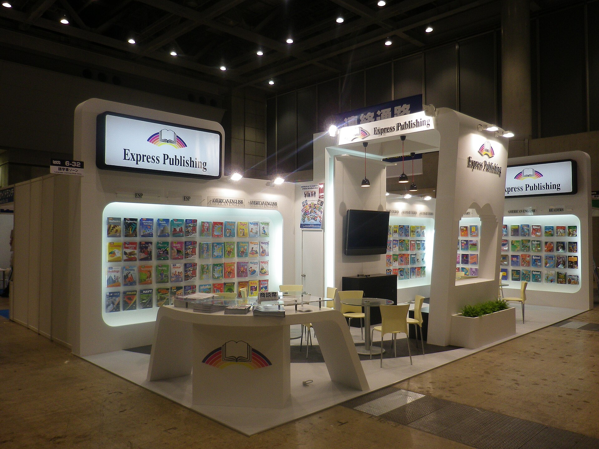Stand de foire du livre avec tables basses et rangées d'ouvrages exposés