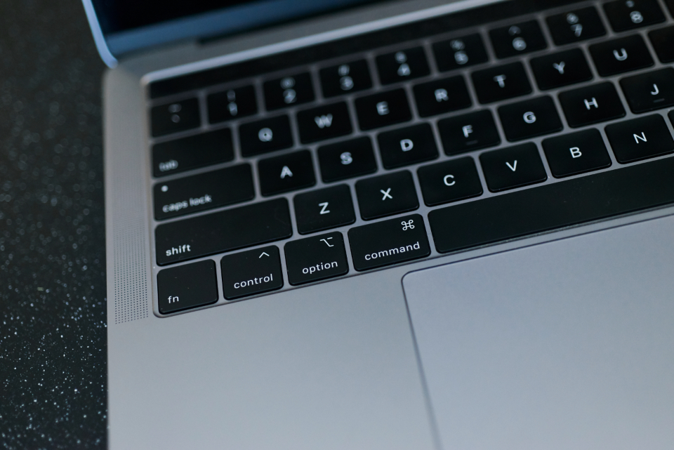 Ordinateur portable ouvert sur un formulaire en ligne, mains pos&eacute;es sur le clavier