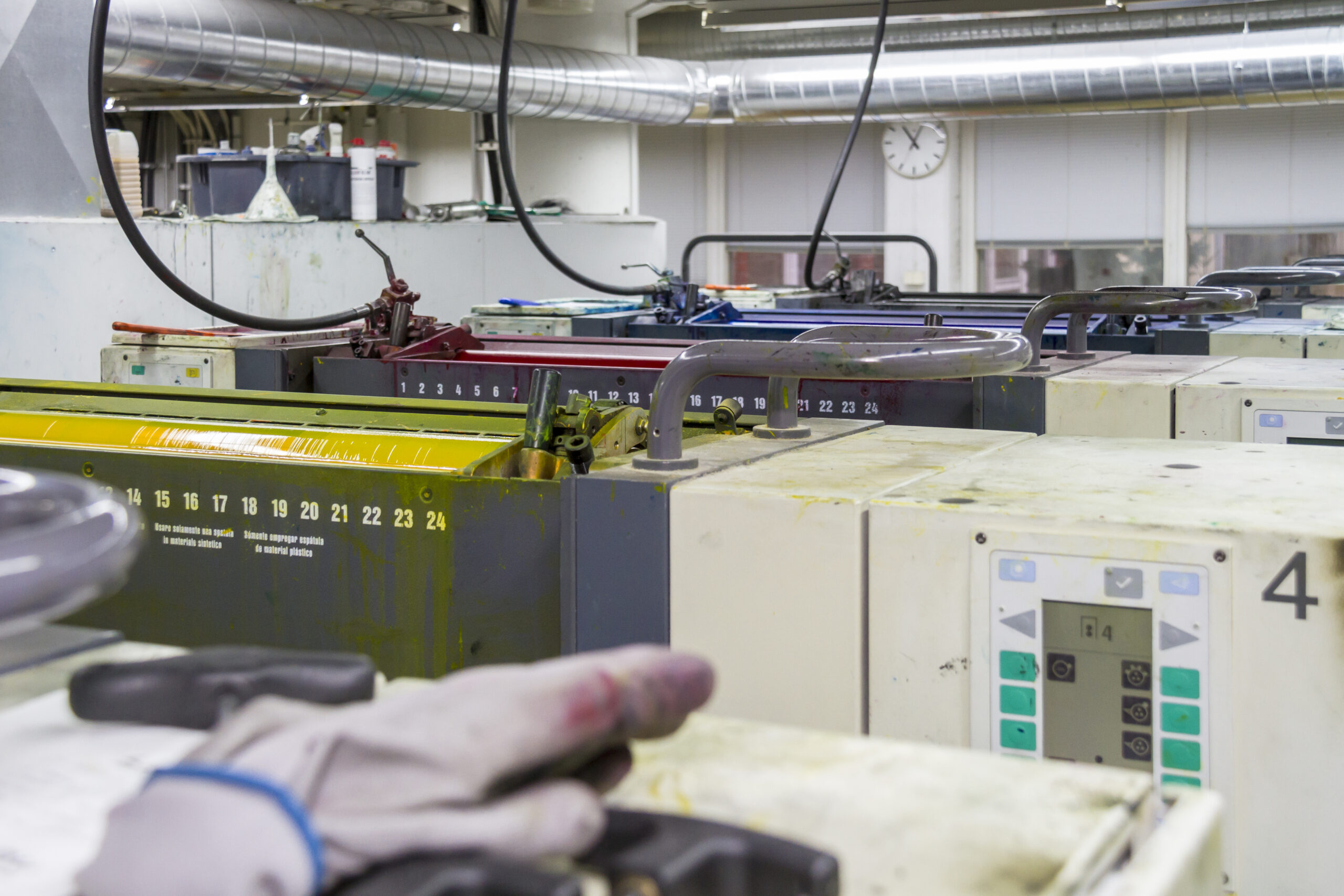 Presse d'imprimerie en fonctionnement, feuilles empilées à la sortie de la machine