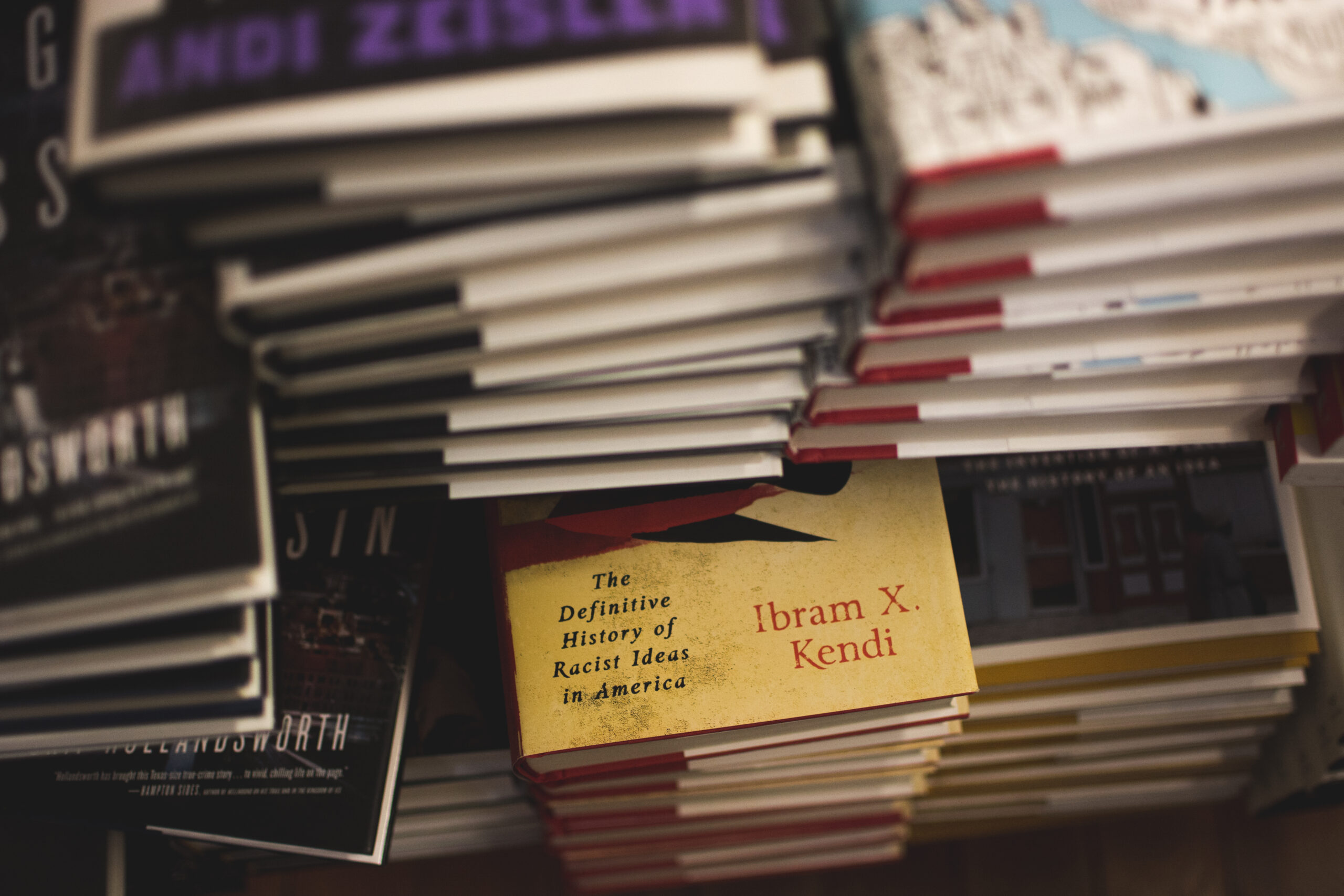 Table de librairie couverte de livres neufs posés à plat, piles basses et étiquettes