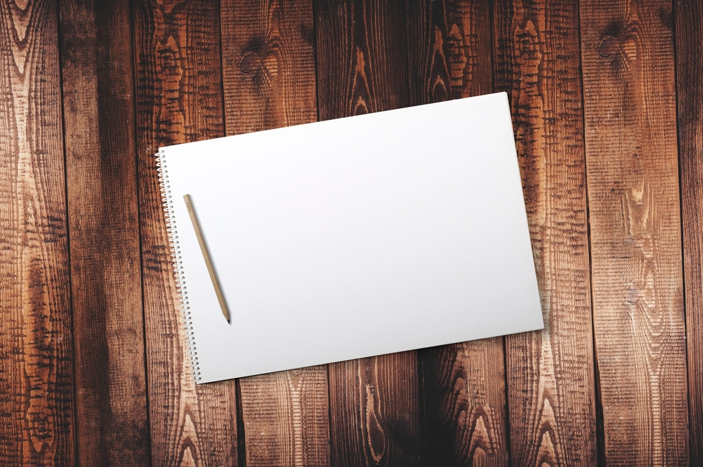 Carnet ouvert et stylo pos&eacute;s sur une table en bois, page couverte de notes